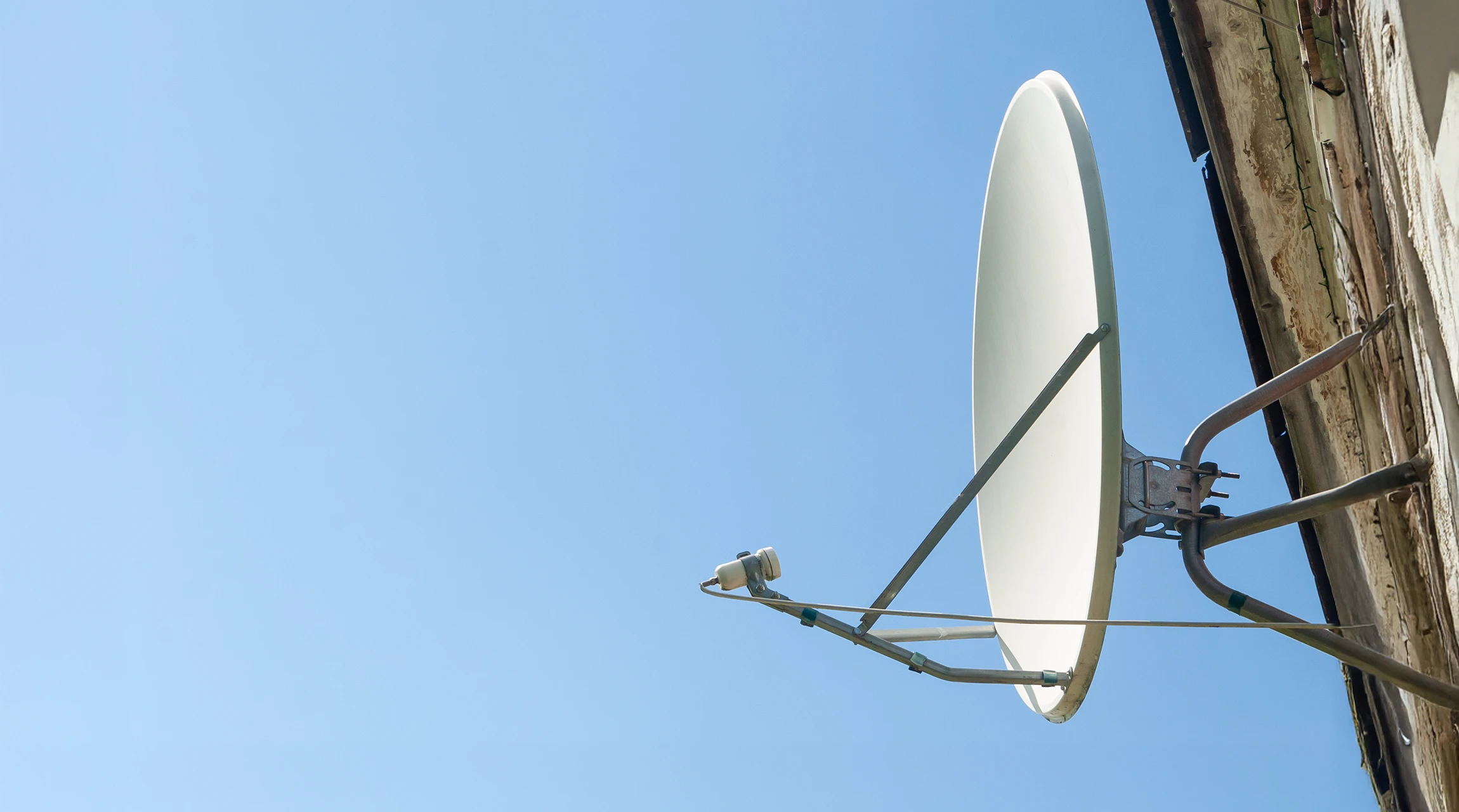 Scène extérieure urbaine avec antennes paraboliques installées sur toiture d'immeuble en briques